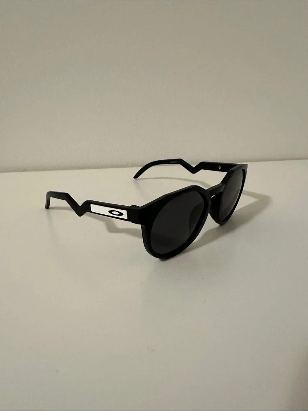 Oakley Black Round Sunglasses with Zigzag Temples and White Logo Accents